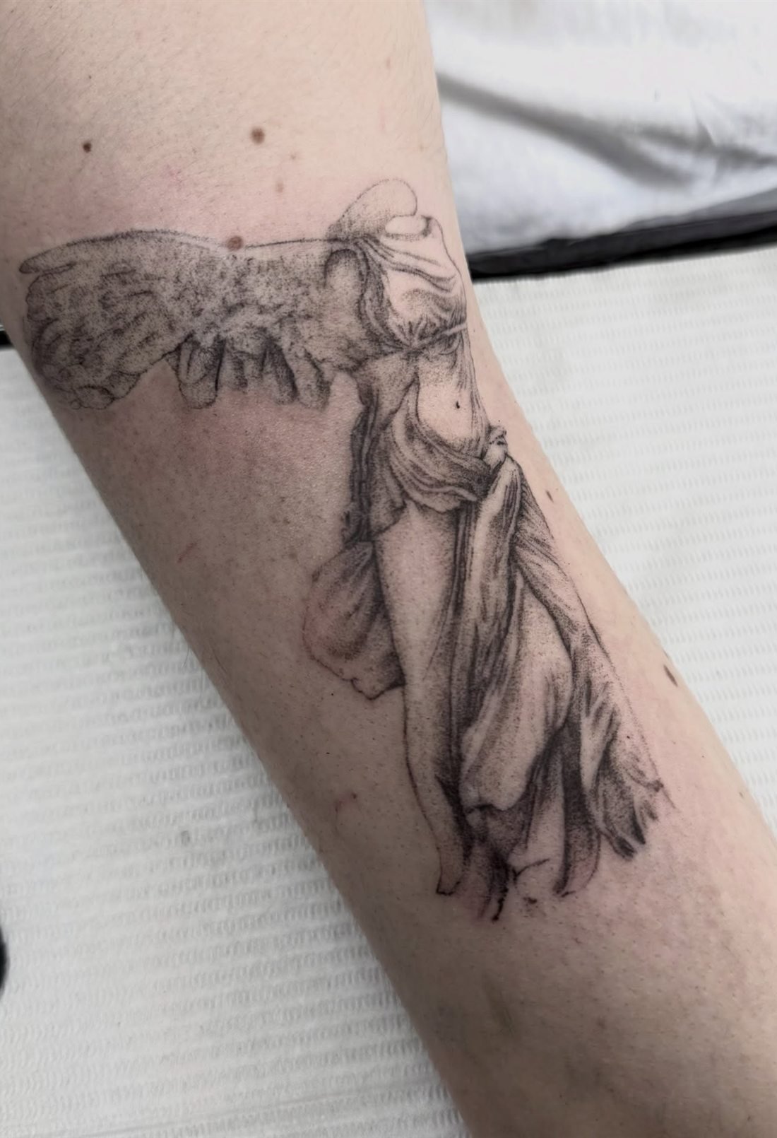 Tatouage de la Victoire de Samothrace en semi-réalisme sur l’avant-bras
