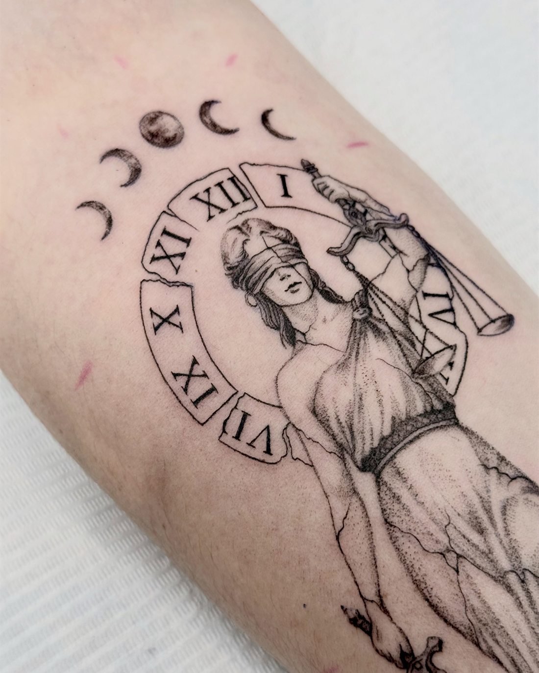 Tatouage de Thémis, déesse de la justice, avec cadran romain et phases de lune